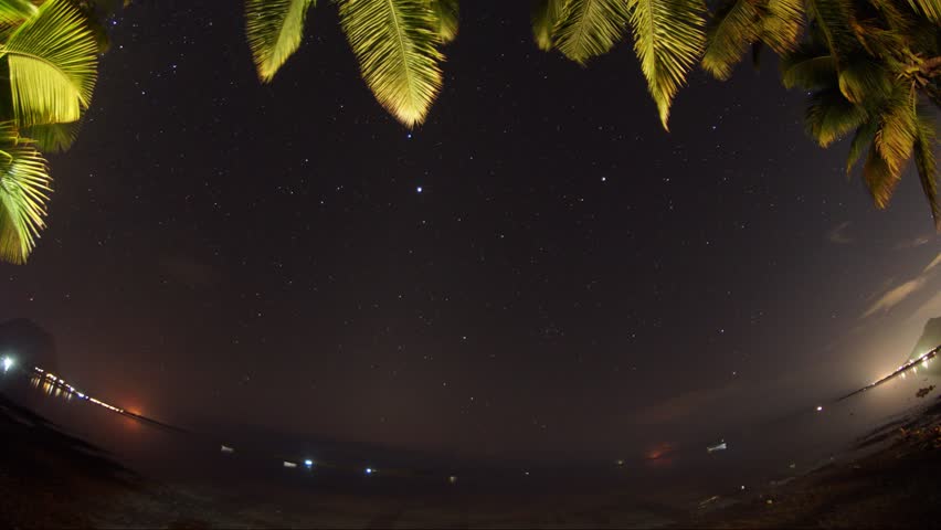 magical static 360 degrees VR time lapse of milky way night with speeding clouds.lights in the surrounding and pine trees hanging around at the background. mauritius island.filmed with drone 4K 30fps