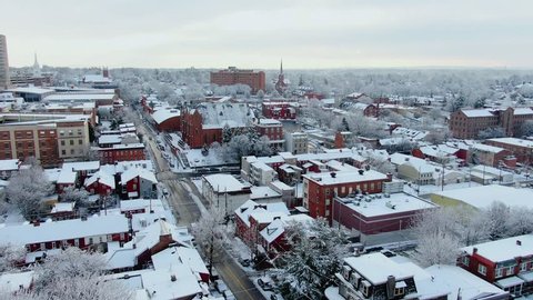 Winter morning in a small American town on the East Coast, trees and roofs of buldings covered in fresh layer of snow, steeples and multi story buldings dominate the skyline, Lancaster, Pennsylvania