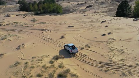 Off road pickup truck driving on sand in desert. Aerial view  