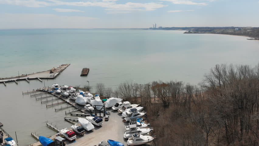 Fly over aerial view of the Michigan lake shore line, pier, yacht club, boats, early spring (april), sunny day
