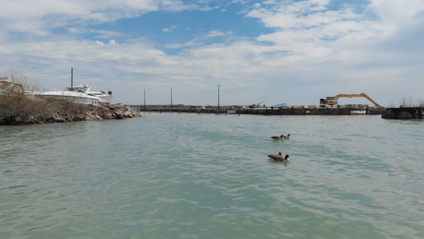 Fly over aerial view of the Michigan lake shore line, pier, yacht club, boats, early spring (april), sunny day
