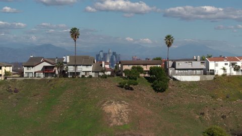 Los Angeles, California / USA - July 16, 2017: Houses on Hill in Los Angeles with Downtown LA Hollywood Skyline in the Background, Aerial Drone