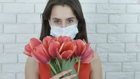 Pollen allergy. Girl in a medical mask with flowers.