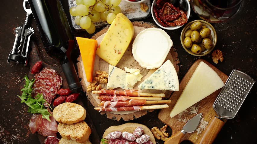 Huge assortment of various tasety spanish, french or italian apertizers. Cheese, meat, olives, stuffed peppers, bread, sticks. Placed on rusty dark background. View from above. | Shutterstock HD Video #1028268683