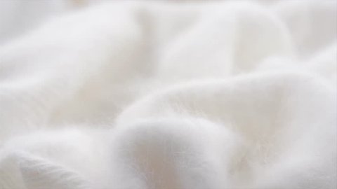 Soft Wool background. Alpaca wool mohair clothes texture closeup. Natural Cashmere Soft and fluffy merino wool macro shot. Woolen fabric. Knitted hairy detail texture surface Rotated. 4K UHD slowmo