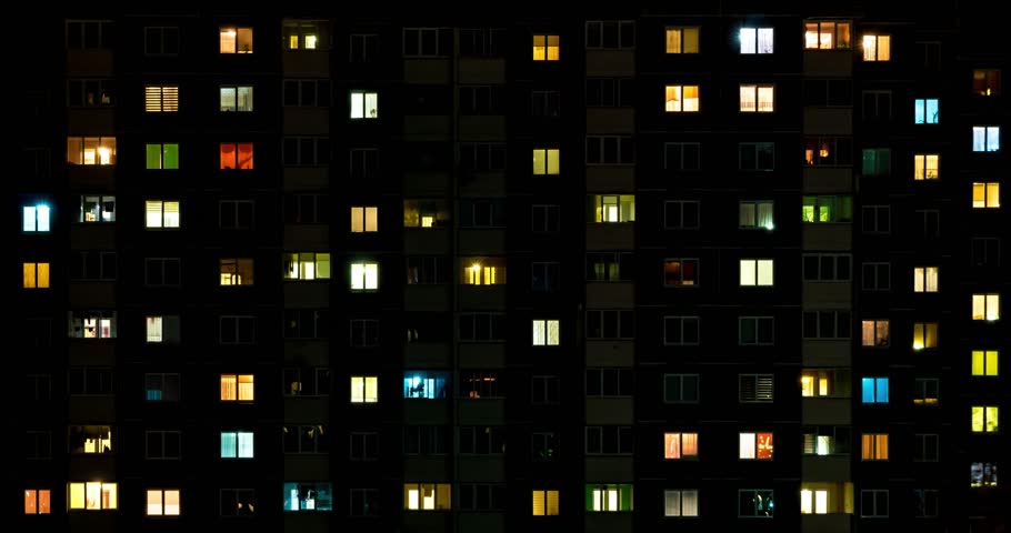 Night time lapse of Light in the windows of a multistory building. life in a big city. Serenade of light