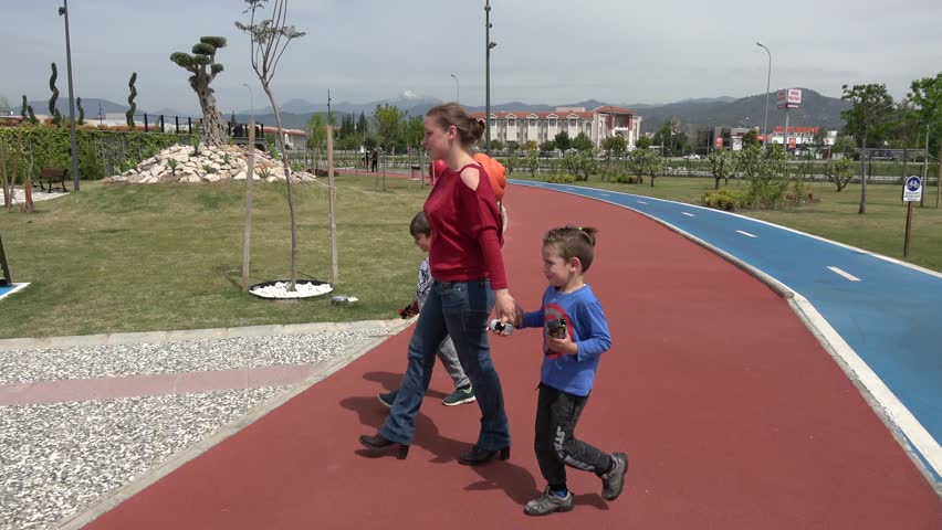 Fethi Bey Park, Fethiye, Turkey - 14th of April 2019: 4K Mother and two boys play lava game in the park
