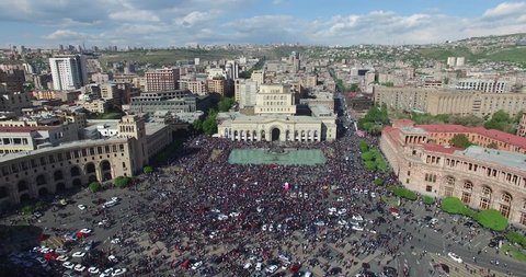 Aerial view velvet, political revolution in Armenia 2018 years, April month. Many people and some cars in square of Yerevan, republic of Armenia. Drone fly over peoples to square building.