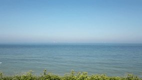 Rising drone footage of the English Channel horizon on a beautiful sunny day
