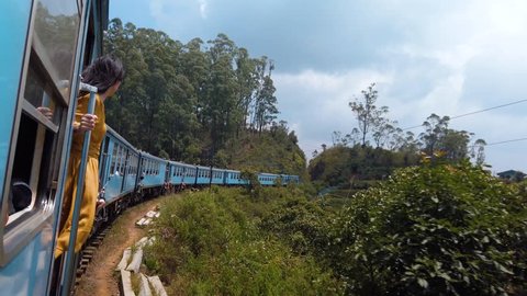 Woman enjoying the train ride through Sri Lanka tea plantations