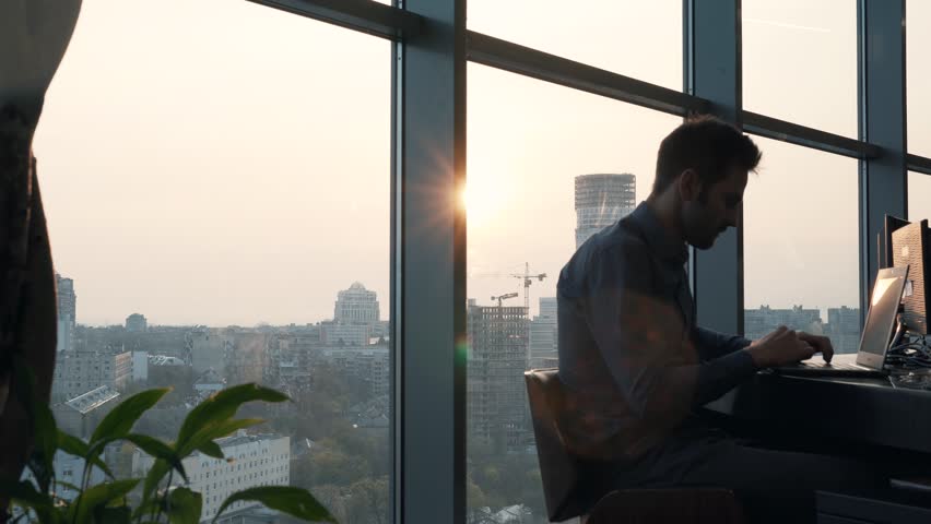 Man Working In Modern Office At Sunrise On Laptop.Creative Man With Computer Overtime Working At Office In Sunset. Businessman Working Alone Morning At Open Space Room.Overtime Work On Laptop Keyboard | Shutterstock HD Video #1028295737