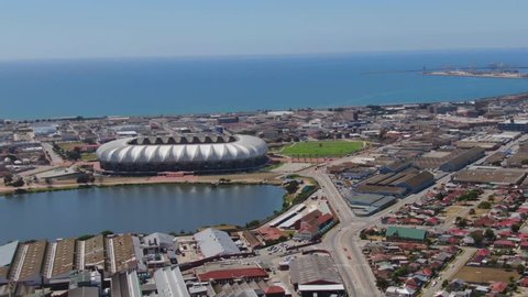 Port Elizabeth, South Africa - circa 2010: Aerial view of city skyline and harbour from Sydenham area. Slow right pan flying around the Nelson Mandela Bay Stadium and North End Lake