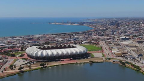 Port Elizabeth, South Africa - circa 2010: Aerial fly over. Central Business District and active port on a sunny summer day. Nelson Mandela Bay Stadium, North End Lake and industrial area close by.