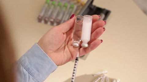 Close-up of a woman with type 1 diabetes gaining one insulin syringe short and prolonged action. Insulin therapy. Slow motion.