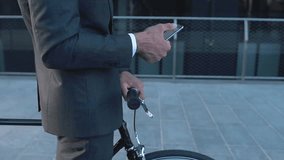 Young businessman going to work in the morning on his modern bicycle. Concept about transportation, business and healthy lifestyle