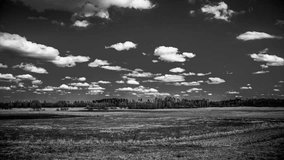 Time lapse of fields in the summer with clouds moving in black and white