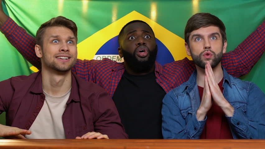 Sports fans with Brazil flag supporting national team, happy about match victory