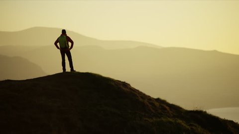 Silhouette of active female adventure hiker achieving her ambitions on the top of mountain at sunset Snowdonia National Park Wales RED MONSTRO