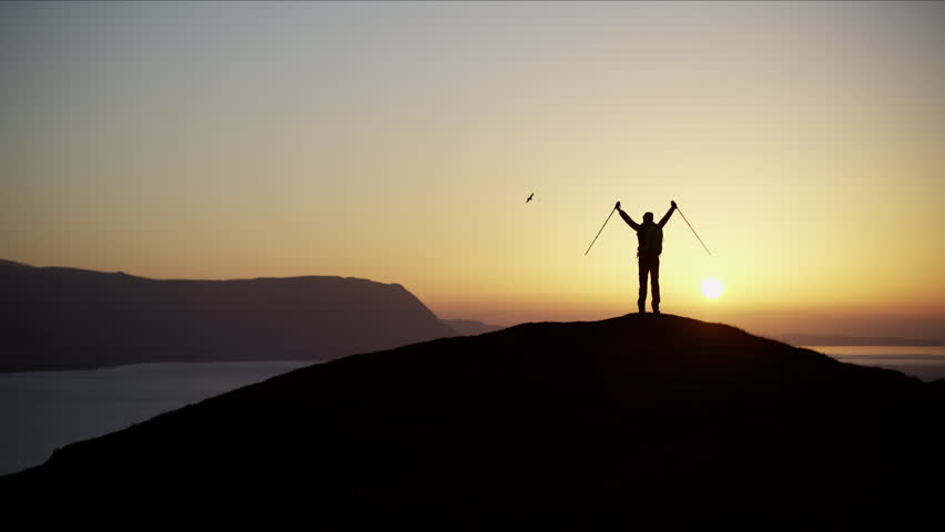 Silhouette of Caucasian European woman traveler celebrating success on the top of mountain at sunrise Snowdonia RED MONSTRO