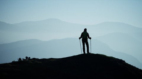 Silhouette of fit Caucasian European woman hiker Nordic walking mountains outdoors at sunset Snowdonia National Park Wales RED MONSTRO