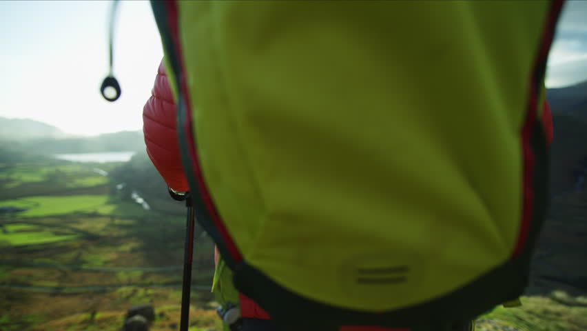 Caucasian European female hiker enjoying hiking with Nordic walking poles on the top of mountain sun flare Snowdonia National Park RED MONSTRO