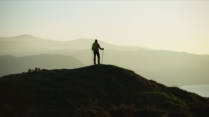 Silhouette of active Caucasian European female adventure hiker enjoying hiking on the top of mountain Snowdonia National Park Wales RED MONSTRO | Shutterstock HD Video #1028326250