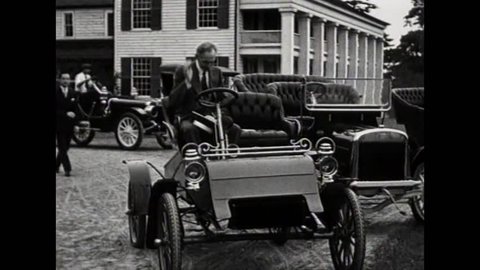 CIRCA 1900s - Henry Ford poses in one of his first Model T cars and other later models.