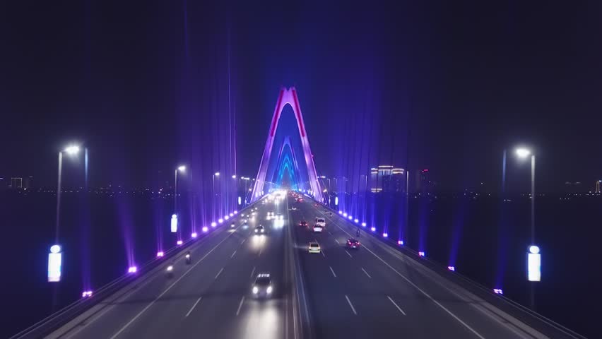 Low span forward inside bridge between pylons Cable-stayed Modern Nhat Tan. Road traffic cars. Beautiful multicolored night neon illumination. Hanoi Vietnam Asia. Travel logistics. Aerial Drone Royalty-Free Stock Footage #1028346431
