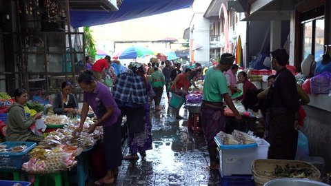 UBUD, BALI, INDONESIA - APRIL 25, 2019 : Poor Indonesian people selling and buying healthy food at the morning market in village Ubud, island Bali, Indonesia. Early morning fruit and vegetable market
