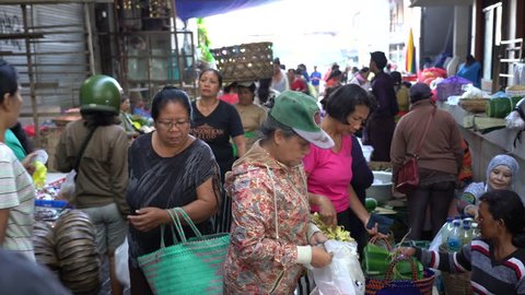 UBUD, BALI, INDONESIA - APRIL 25, 2019 : Poor Indonesian people selling and buying healthy food at the morning market in village Ubud, island Bali, Indonesia. Early morning fruit and vegetable market