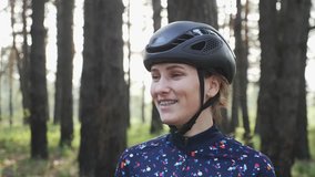 Woman on bike. Girl Cycling training. Portrait of young attractive girl putting glasses on before cycling wearing black helmet and blue jersey. Cycling Concept. Slow motion