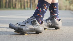 Woman cycling. Girl bicycle training. Cyclist girl tightens road shoes before the bicycle ride. Close up. Slow motion