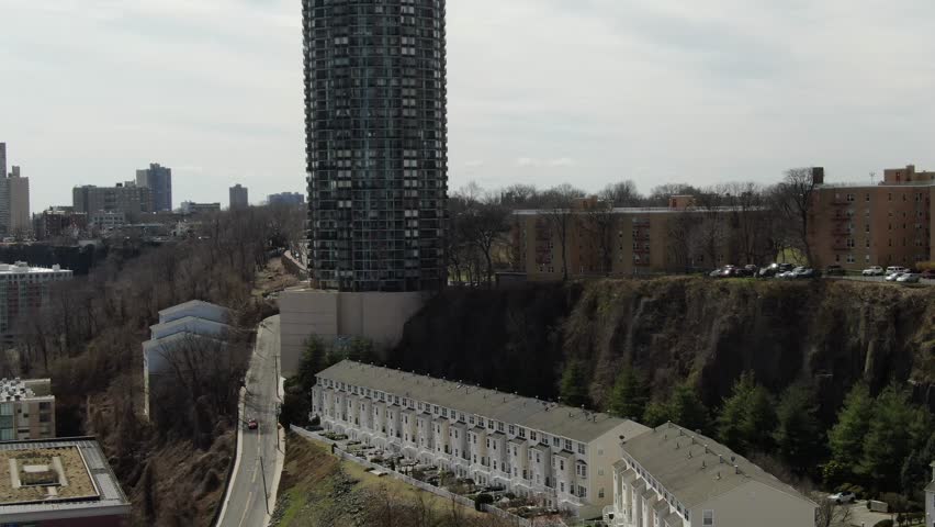 Cylindrical glass tower rising over the New Jersey Palisades, 2019.