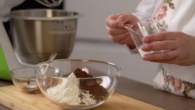 A woman prepares delicious cupcakes in the kitchen. The video shows the complete process of making homemade muffins. The whole recipe, from kneading dough, the layout of the molds, baking in the oven.