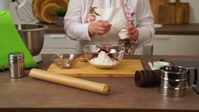 A woman prepares delicious cupcakes in the kitchen. The video shows the complete process of making homemade muffins. The whole recipe, from kneading dough, the layout of the molds, baking in the oven.