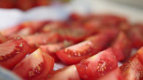 Appetizing red sliced tomatoes sprinkled with spices. Concept of eating and cooking. Slow motion 4K close up video.