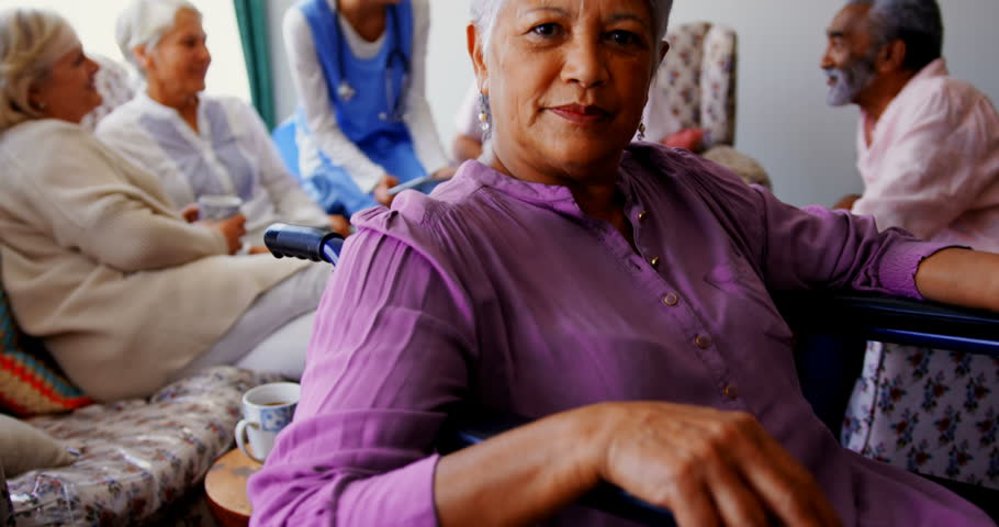 Front view close up of active African american senior woman in the nursing home. Senior friends interacting with each other in the background. | Shutterstock HD Video #1028363297