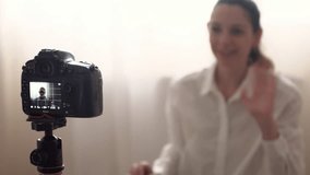 Attractive caucasian woman famous blogger is recording video for her online vlog using camera home