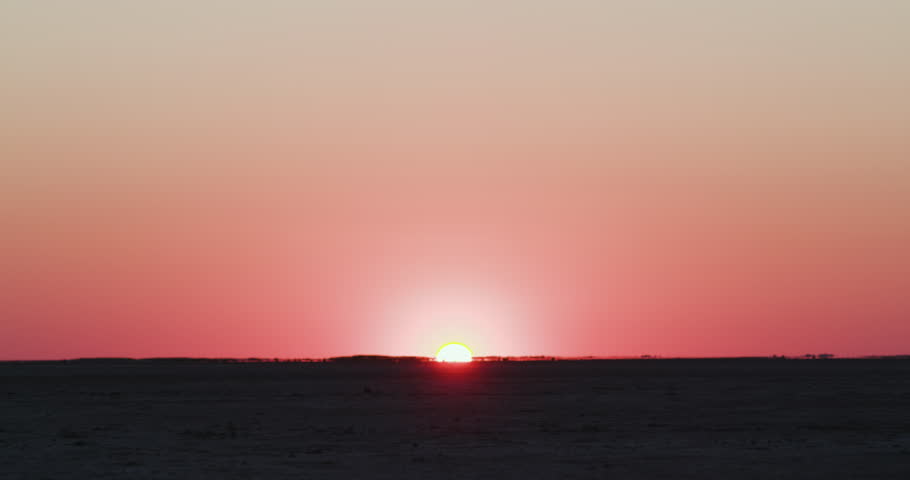 Close-up view of a group of Bushman walking on the Makgadikgadi Pans with the sun setting in the background, Botswana Royalty-Free Stock Footage #1028366828