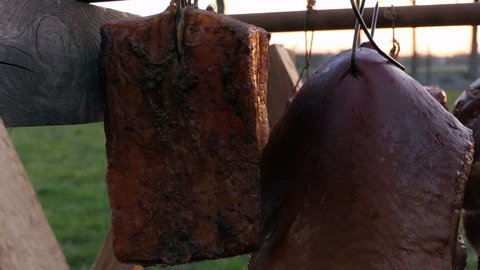 Slow motion shot of various homemade smoked meat drying after smoking process.
