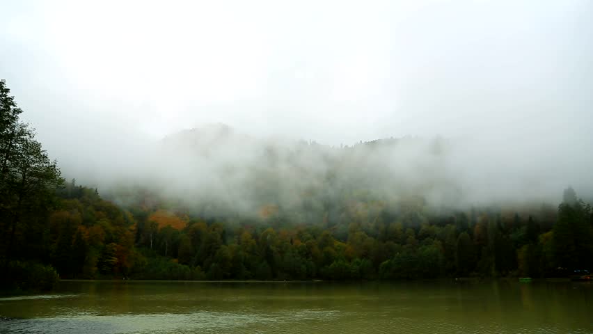 Fog and Clouds over Lake and Mountains. Flying Over Lake In Forest	