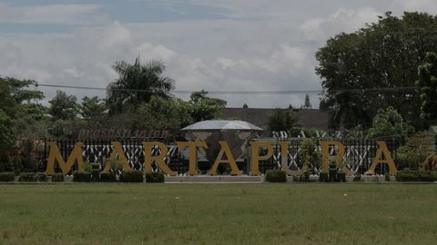 BANJAR, INDONESIA - 04/03/2019: Alphabet letters of Martapura word, the capital of Banjar regency that also known as Land of Diamond, with diamond replica, cloudy blue sky and trees as background.