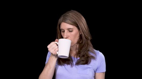 A woman takes a sip of a terrible drink and spits it back into the cup
