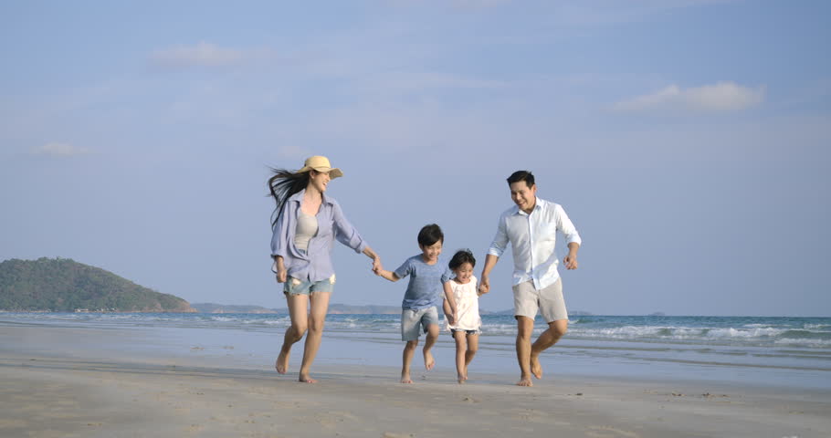 Asian family running with happy emotion at Beach together. Slow motion. Family, Holiday and Travel concept.