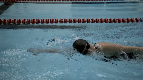 Side view of professional female athlete performing front crawl in swimming pool, Slow motion, Full HD steady shot