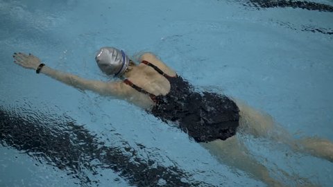 Top view of female amateur swimmer doing front crawl in swimming pool, Slow motion, Full HD steady shot