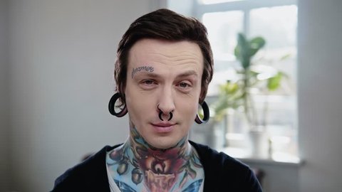 Portrait of alternative model with earplugs and tattoo Stock Video