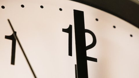 Black and white clock face approaching 12 o'clock
