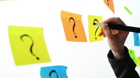 Businesswoman writing question marks on colorful sticky note paper on office whiteboard, selective focus - Powered by Shutterstock - Get 15% off with code: PIKWIZARD15