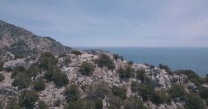 Drone shot of people walking on cliff rocks in Ibiza. Ocean. Follow me around. Hiking. Balearic Islands. Traveling Europe. Spain. Beautiful place. Travel video.